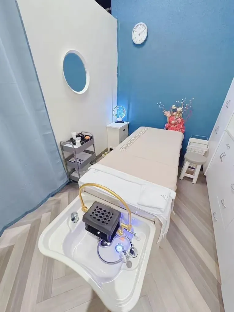 The head spa room at Pacific Massage & Head Spa, with the reclining basin, folded towels and low warm lighting