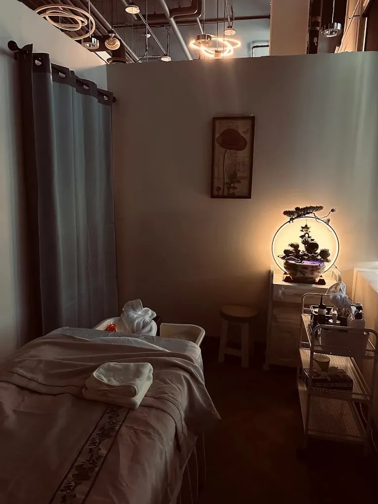 A private massage room with the table made up and low lamplight at Pacific Massage & Head Spa in Redmond, WA